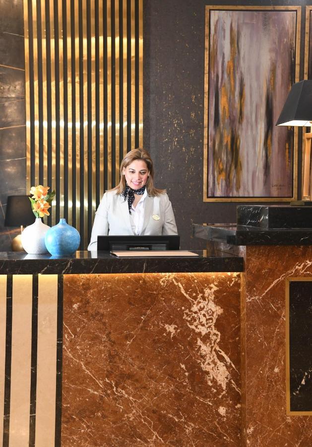 Tolip Gardens Hotel Le Caire Extérieur photo A hotel receptionist at the front desk